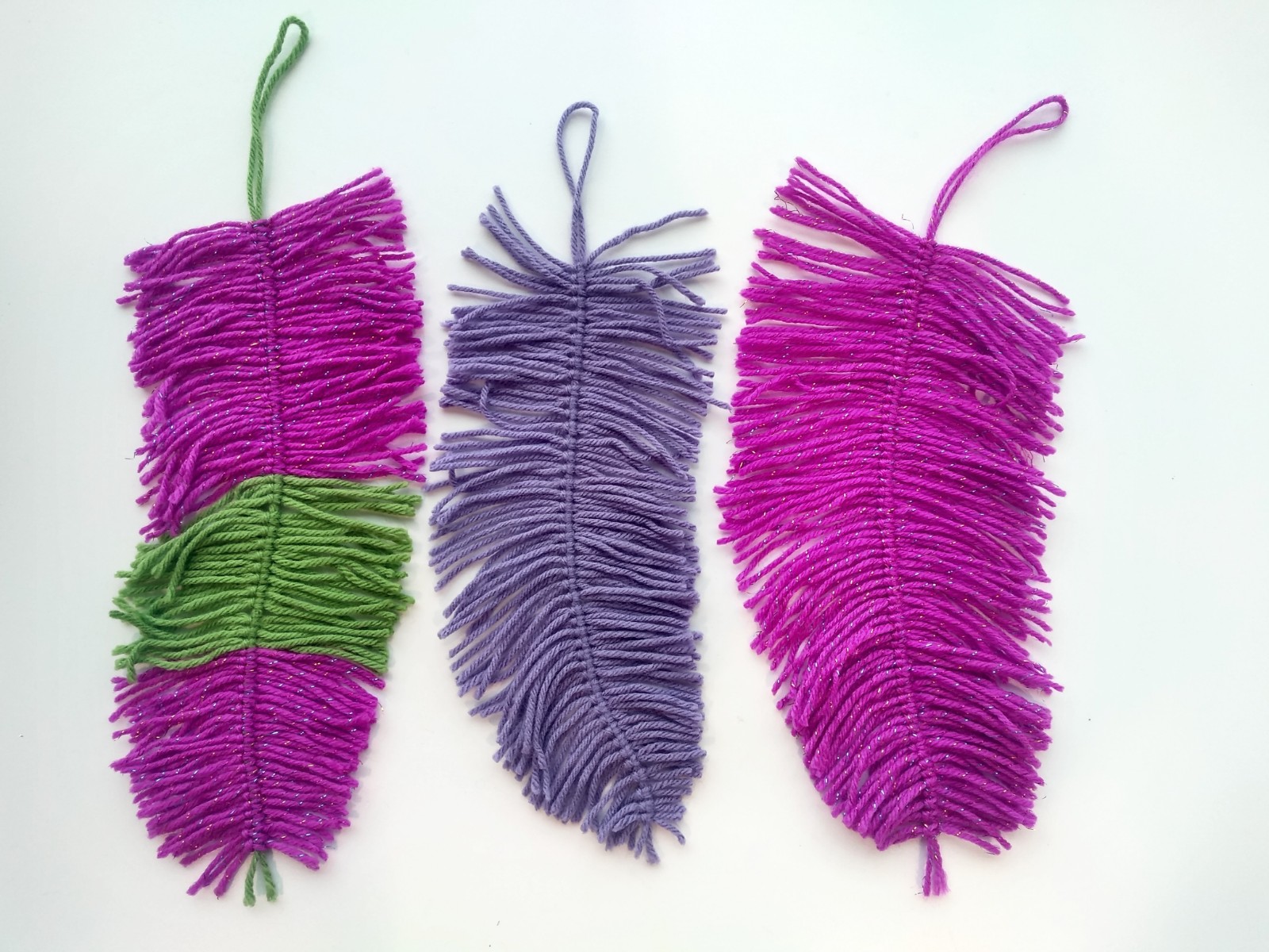 Three yarn feathers.