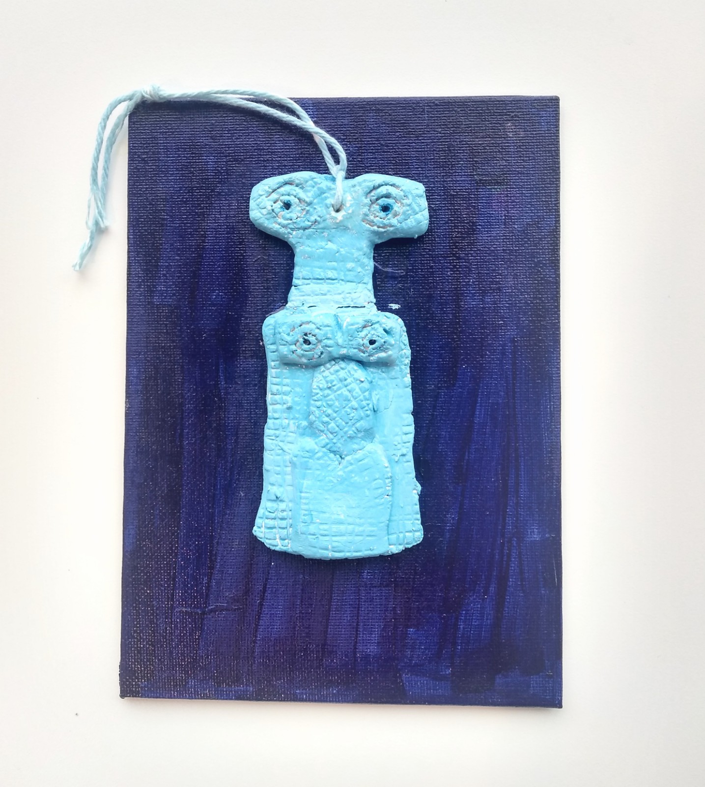 A light blue sculpture icon on a dark blue background.