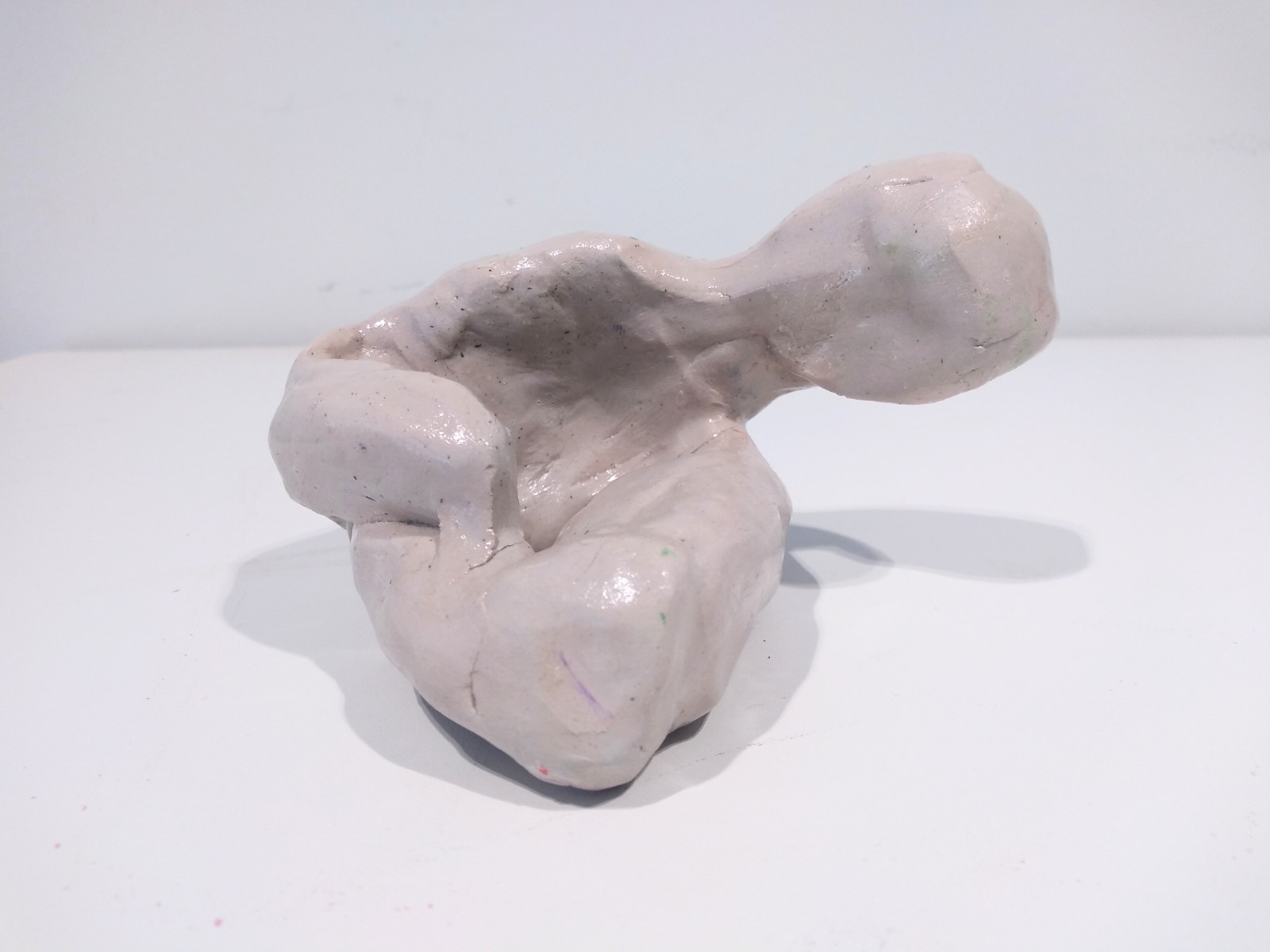 Folded human figure with head to the side.