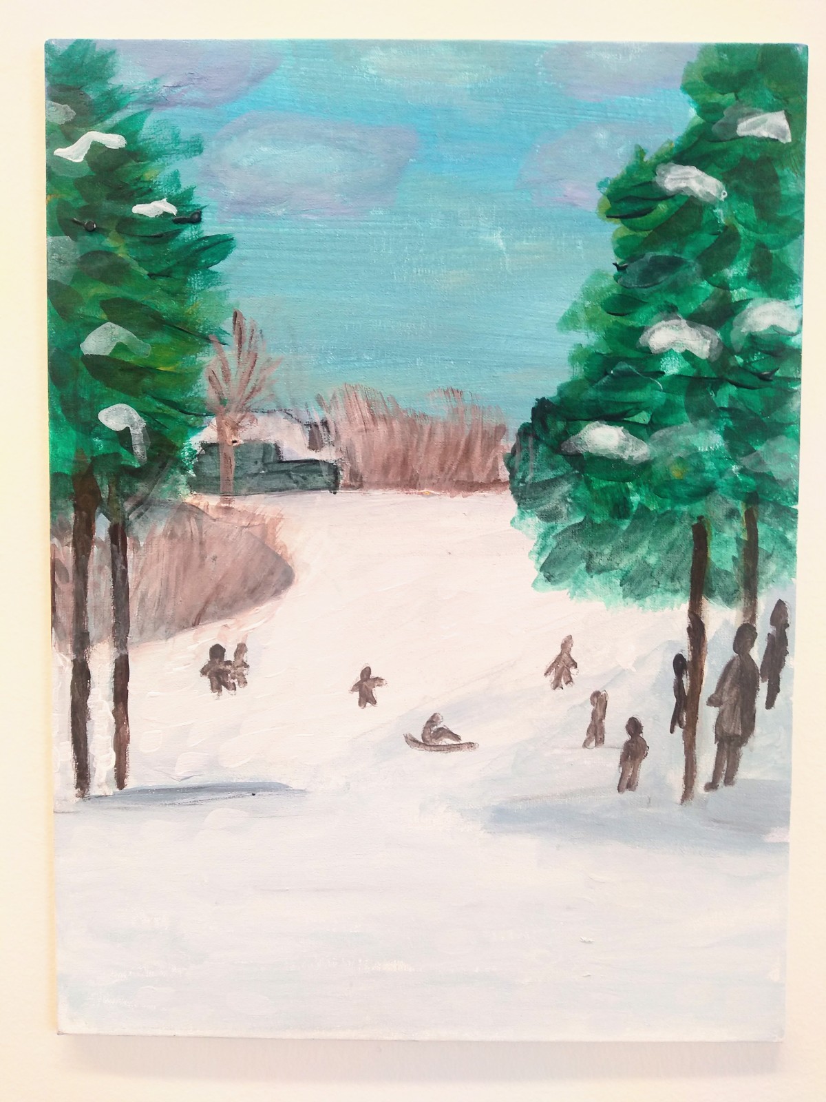 A portrait of people playing in the snow with two trees on each side.