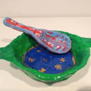 Green dish around blue base with yellow stars and a spoon.