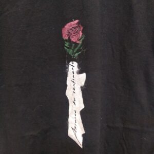 Red rose with green stem and text vertical reads Absence de sentiment with a brain attached to anatomical heart on black shirt.
