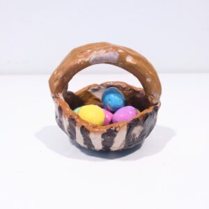 Colourful easter eggs in a brown stripe basket.