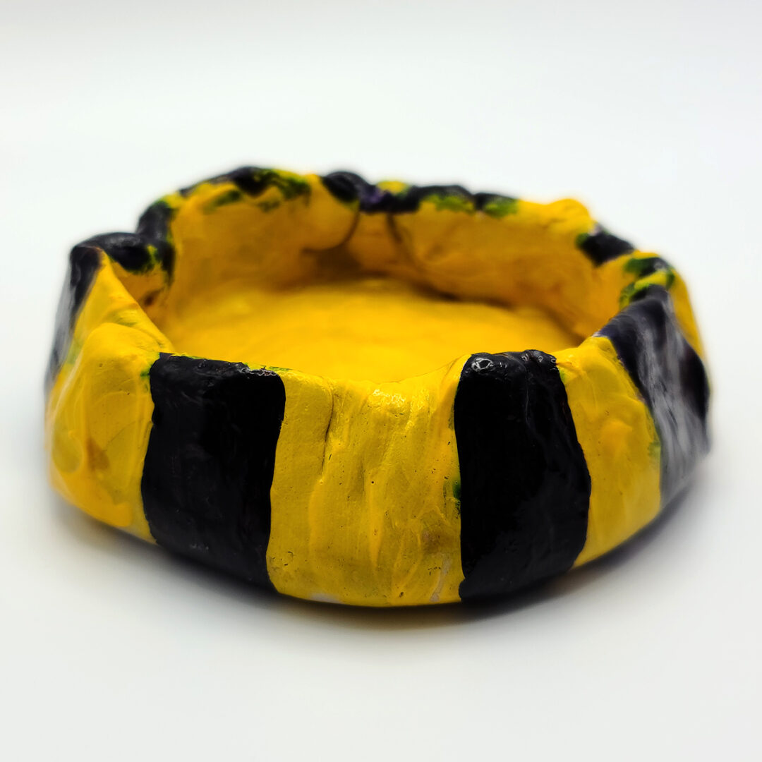 Clay bowl painted in yellow and dark blue stripes.