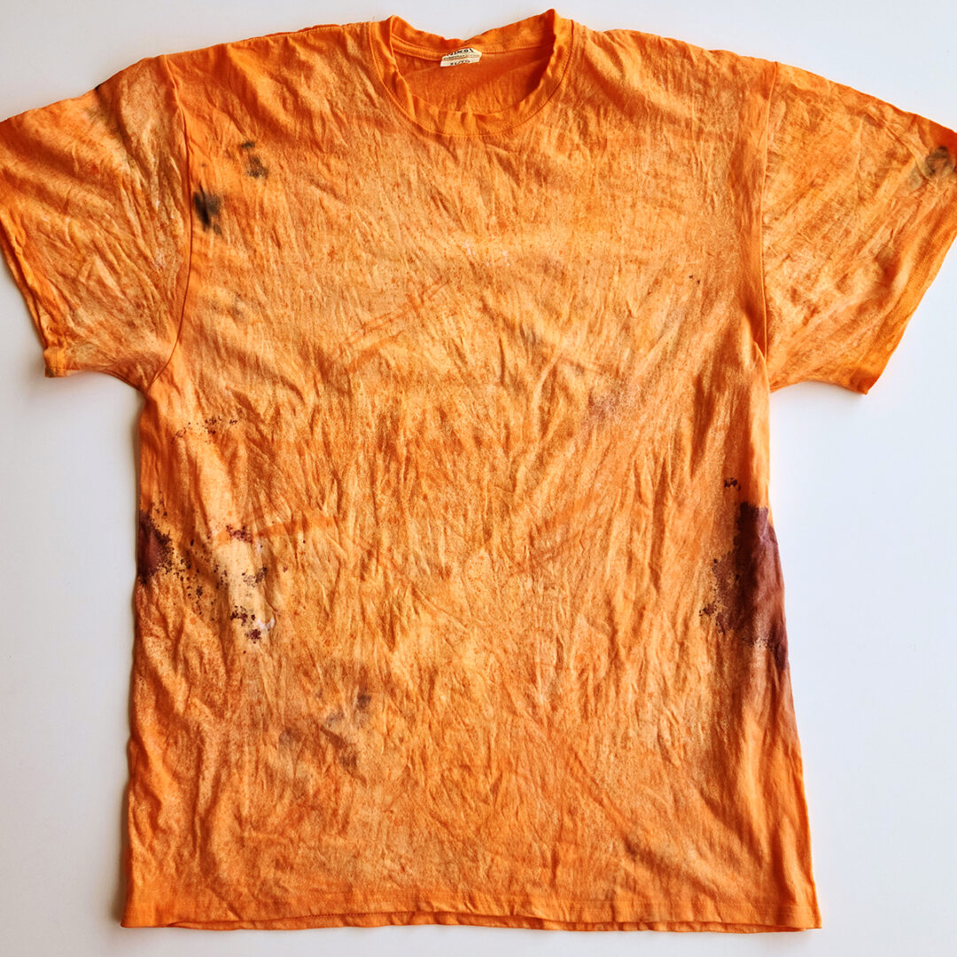 Orange tie dyed shirt with red splatter on the sides.
