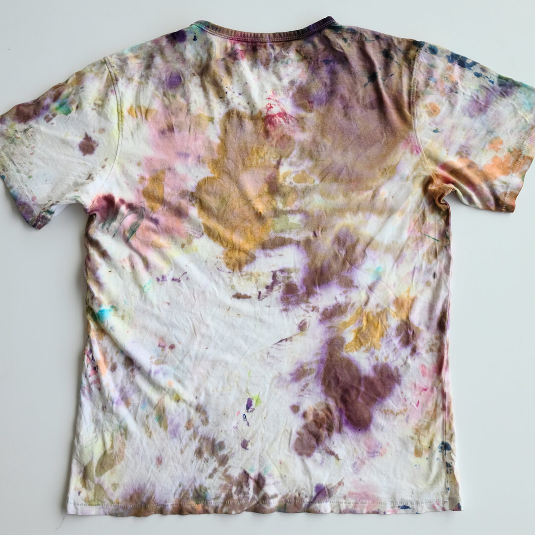 White t-shirt tie dyed with splatters of orange, red and purple.