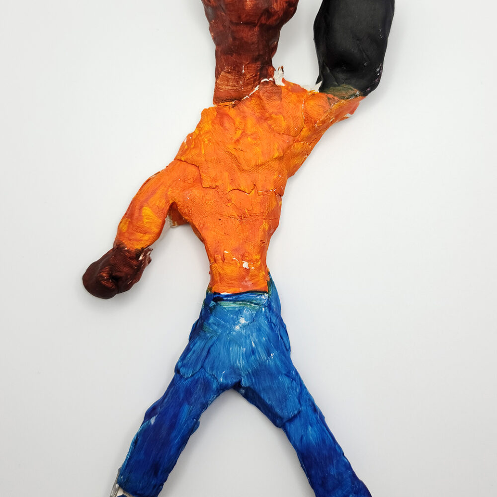 Clay sculpture of a human fugure with an orange torso and blue legs.