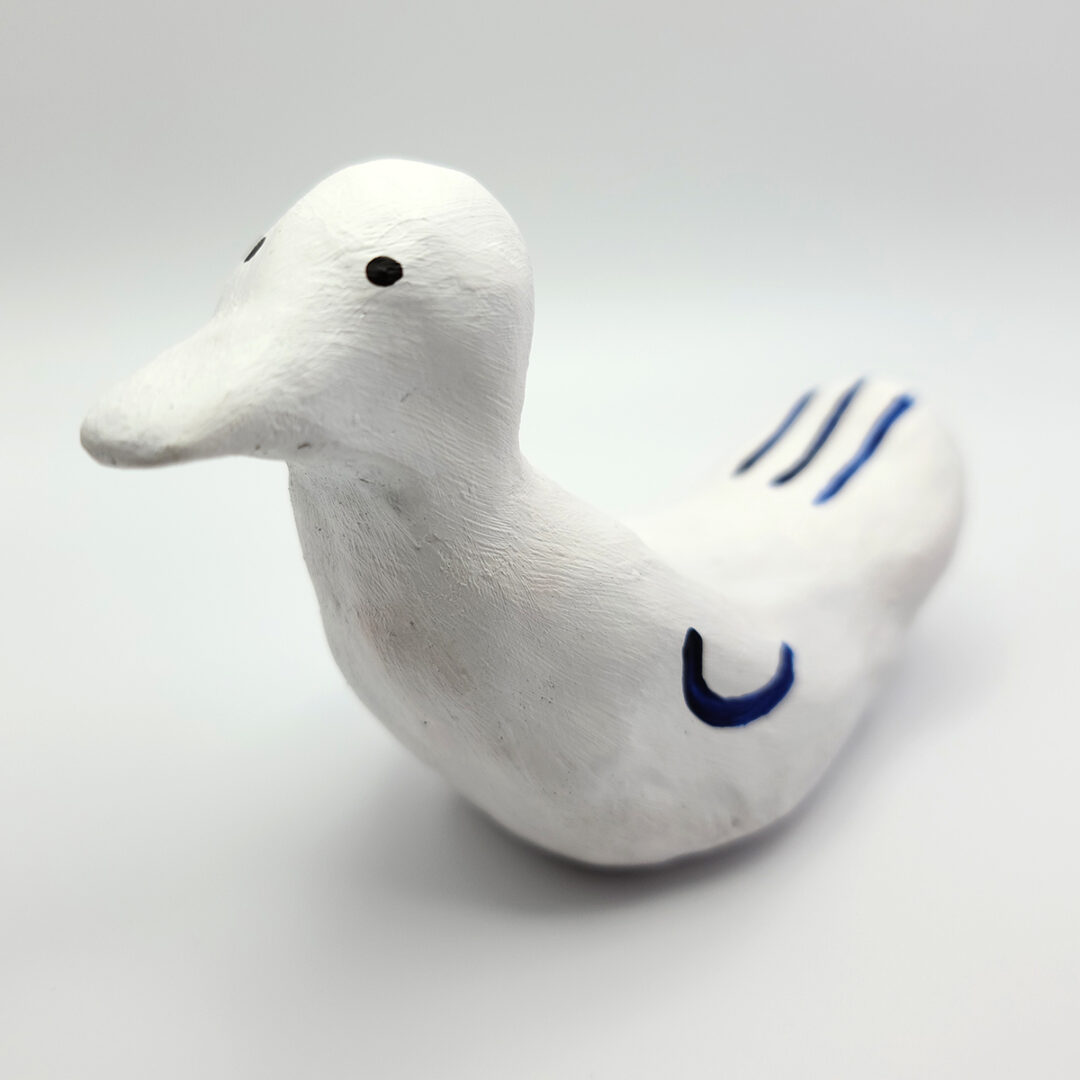 Sculpture of a white bird with blue details.