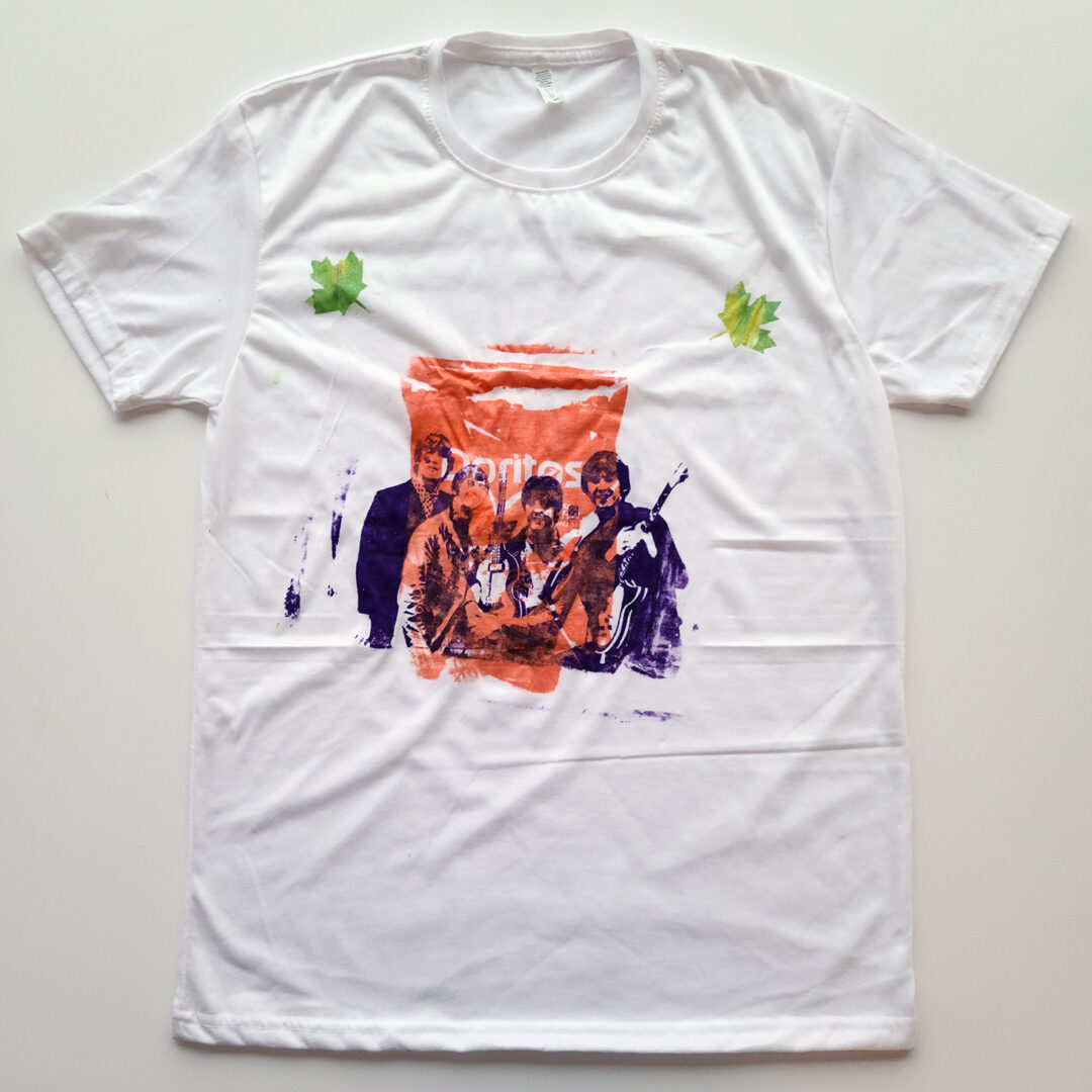 An image of the Beatles in purple is screenprinted overtop an image of a Doritos bag in orange on a white t shirt.