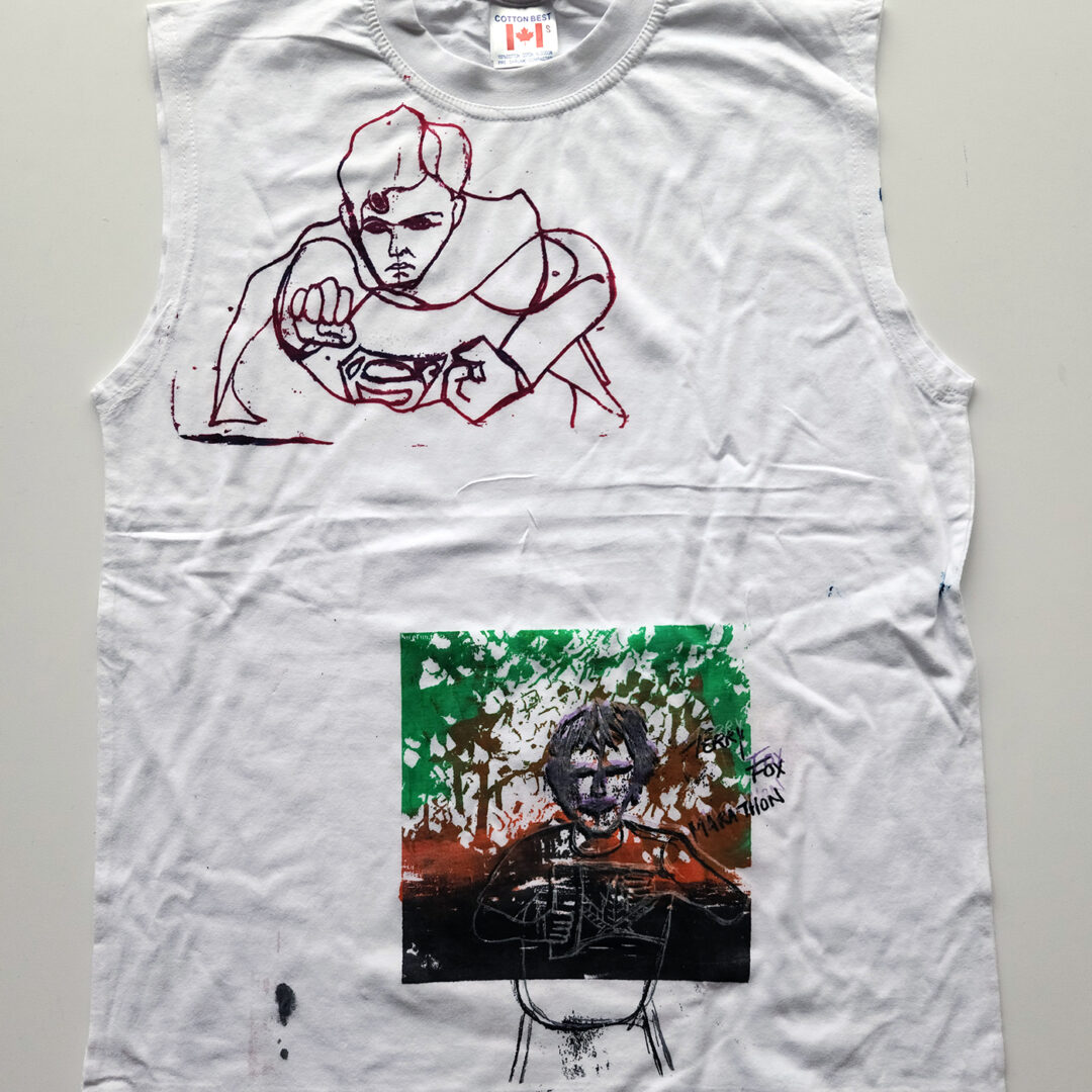 A white t shirt screenprinted with an illustration of Superman on the top left and Terry Fox on the bottom.