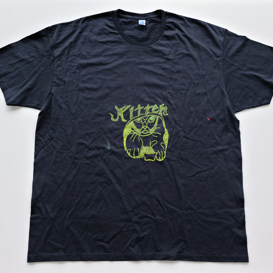 Black t shirt screenprinted with an illustration of a cat with the word 'Kitten' in green.