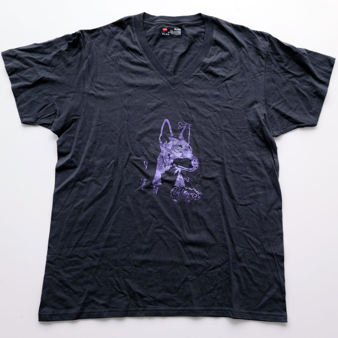 Black t shirt screenprinted with an illustration of a dog with the word 'Mutt' below it in purple.