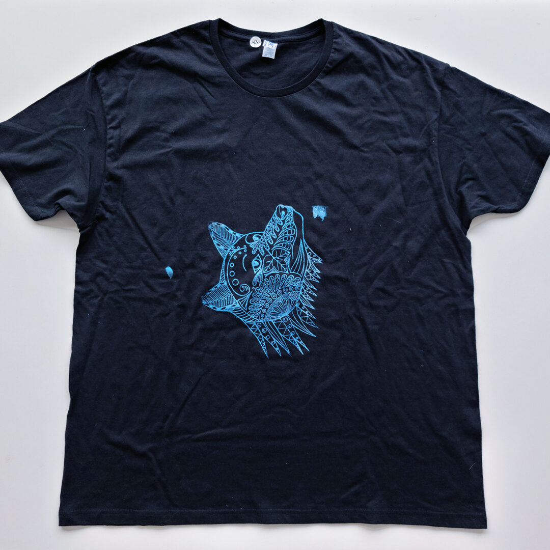 Black t shirt screenprinted with an illustration of a dog with line art inside its face done in blue.